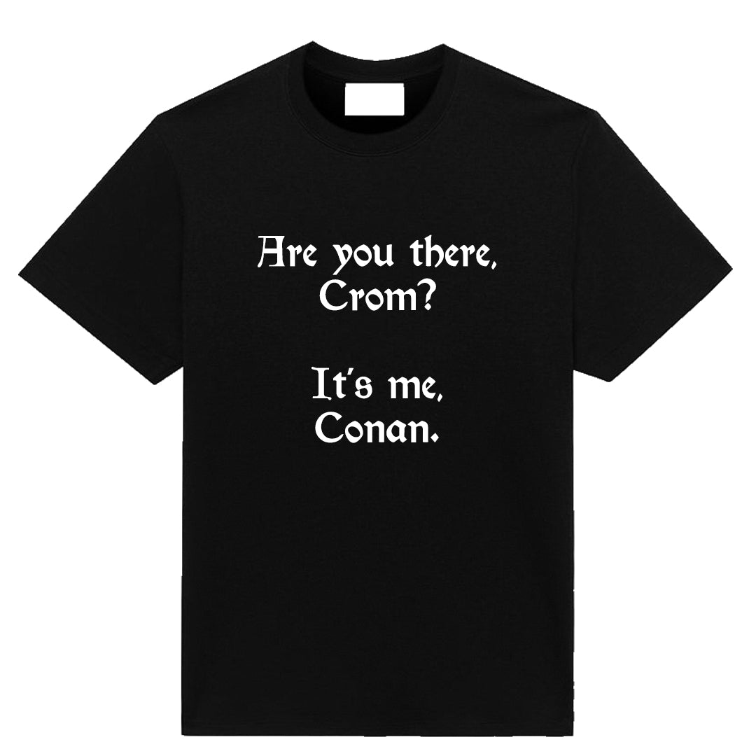 A minimalist fantasy parody T-shirt titled ‘Crom-ulent,’ featuring the line ‘Are you there Crom, it’s me Conan,’ printed on a soft, high-quality tee